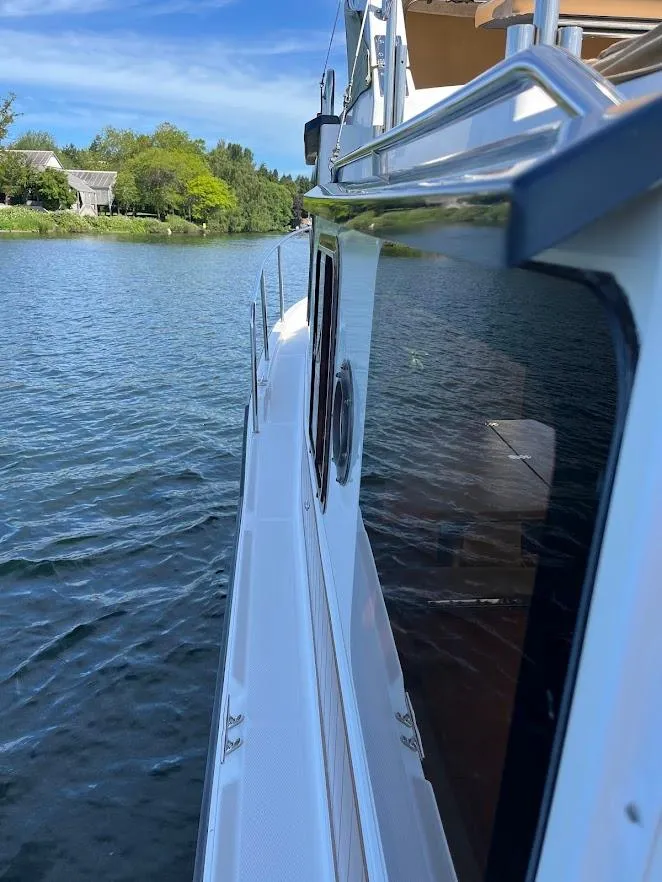 Slide: The Image of 2013 Ranger Tugs R-31 CB boat cruising on a serene lake with lush greenery. - 9