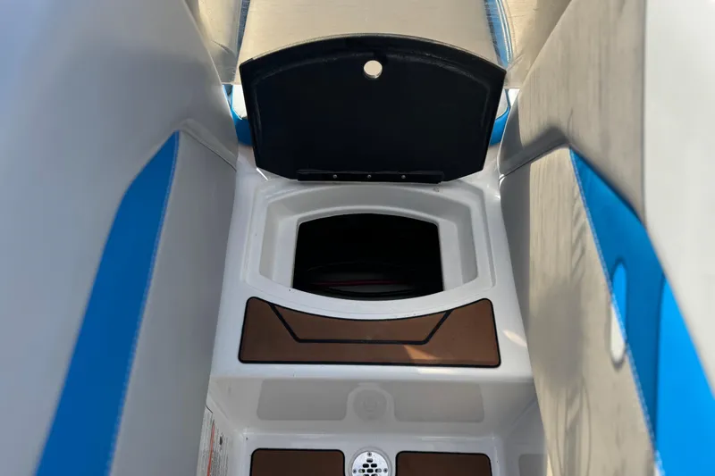 Slide: The Image of 2023 Malibu Wakesetter 21 LX interior storage compartment with blue and white seating. - 14