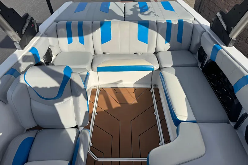Slide: The Image of 2023 Malibu Wakesetter 21 LX interior with blue and white seating, brown flooring. - 15