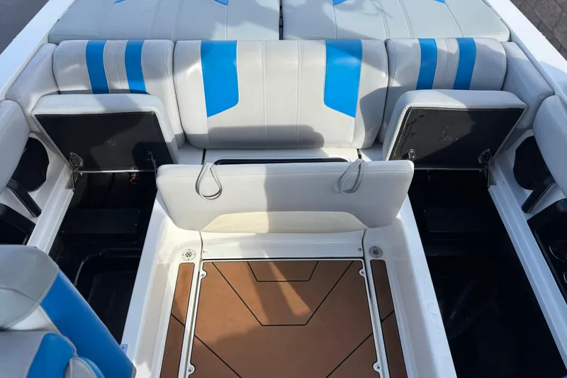 Slide: The Image of 2023 Malibu Wakesetter 21 LX interior with blue and white seating, open storage compartments. - 20