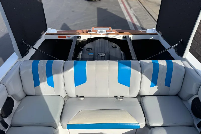 Slide: The Image of 2023 Malibu Wakesetter 21 LX interior with blue-accented seating and open engine compartment. - 21