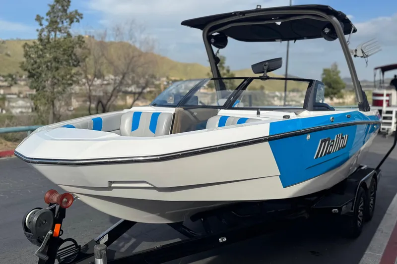 Slide: The Image of 2023 Malibu Wakesetter 21 LX boat on trailer, blue and white design. - 3