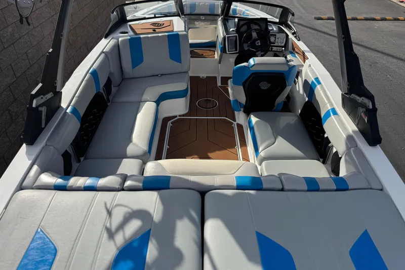 Slide: The Image of 2023 Malibu Wakesetter 21 LX interior with blue and white seating, modern dashboard. - 9