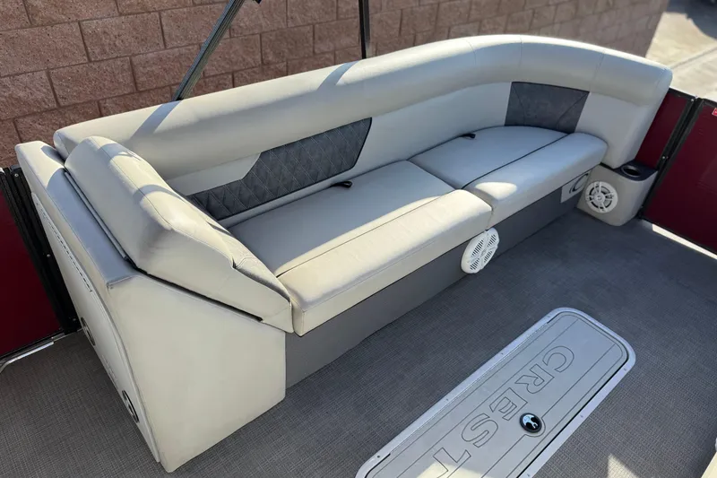 Slide: The Image of 2021 Crest Classic DLX 240 SLC boat interior with cushioned seating and speakers. - 11