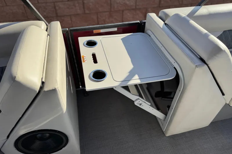 Slide: The Image of 2021 Crest Classic DLX 240 SLC boat interior with foldable table and cup holders. - 17