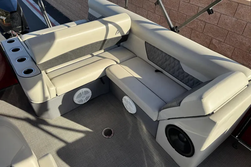 Slide: The Image of 2021 Crest Classic DLX 240 SLC boat interior with beige seating and built-in speakers. - 19