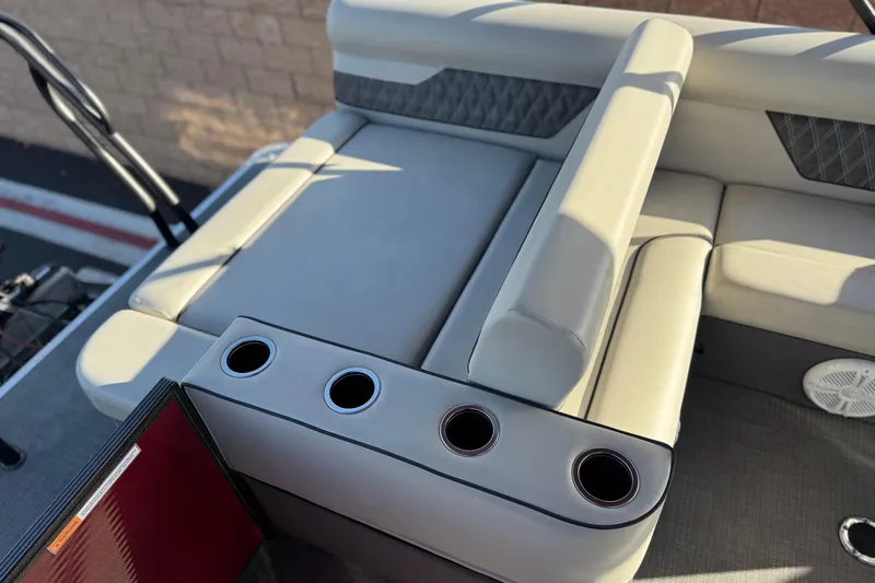 Slide: The Image of 2021 Crest Classic DLX 240 SLC boat interior with cushioned seating and cup holders. - 21