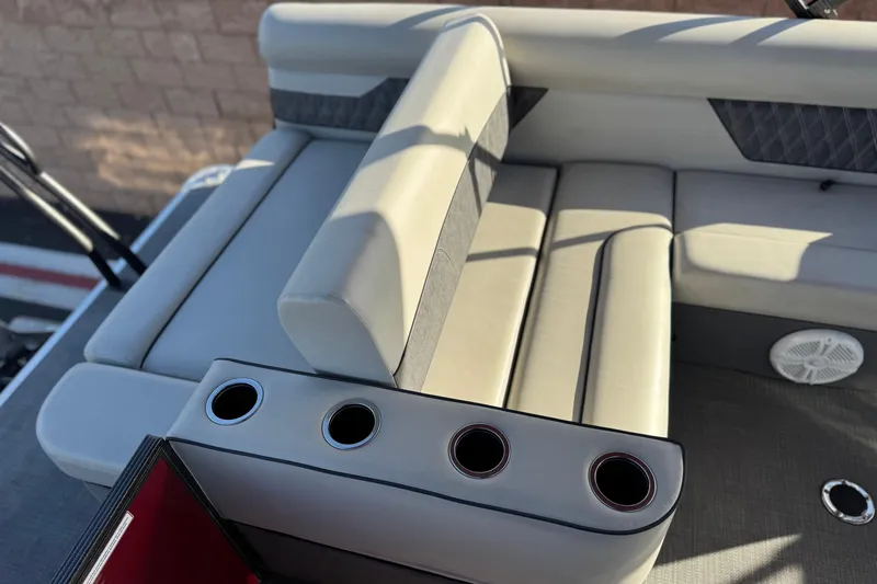 Slide: The Image of 2021 Crest Classic DLX 240 SLC boat interior with cushioned seating and cup holders. - 22