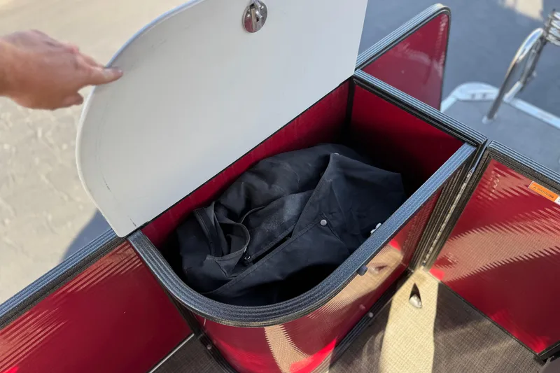 Slide: The Image of Open storage compartment on 2021 Crest Classic DLX 240 SLC boat with black bag inside. - 25