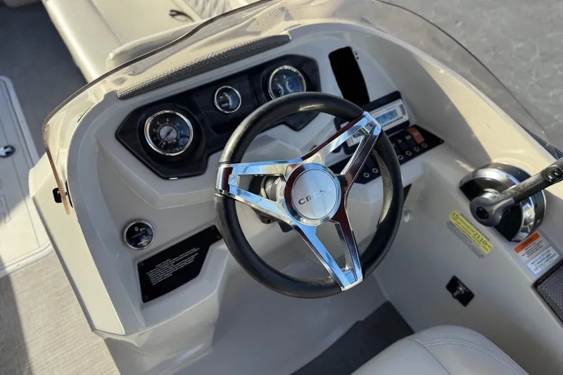 Slide: The Image of Steering console of 2021 Crest Classic DLX 240 SLC boat with chrome accents. - 30