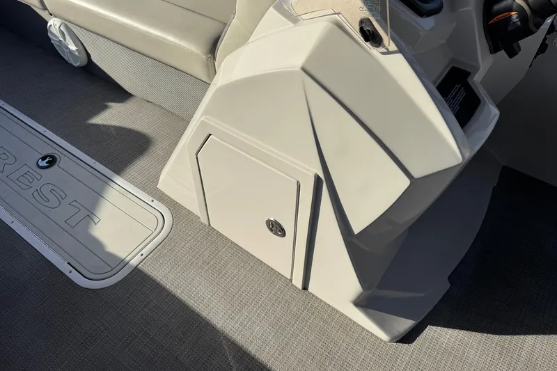 Slide: The Image of 2021 Crest Classic DLX 240 SLC boat interior with storage compartment and seating. - 31