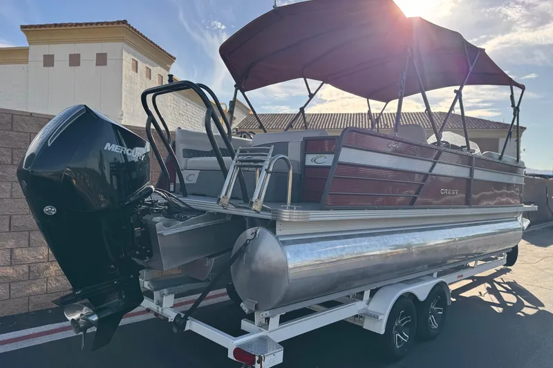 Slide: The Image of 2021 Crest Classic DLX 240 SLC pontoon boat with Mercury outboard engine on trailer. - 6