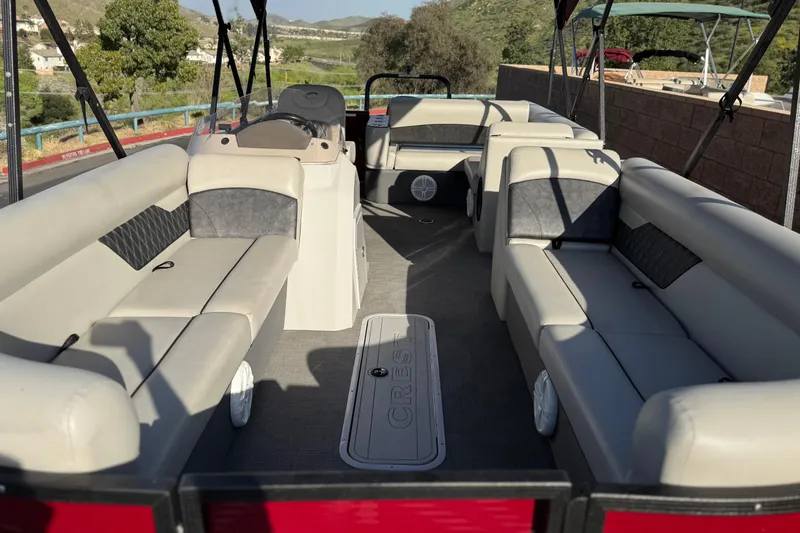 Slide: The Image of 2021 Crest Classic DLX 240 SLC pontoon boat interior with spacious seating and helm. - 9