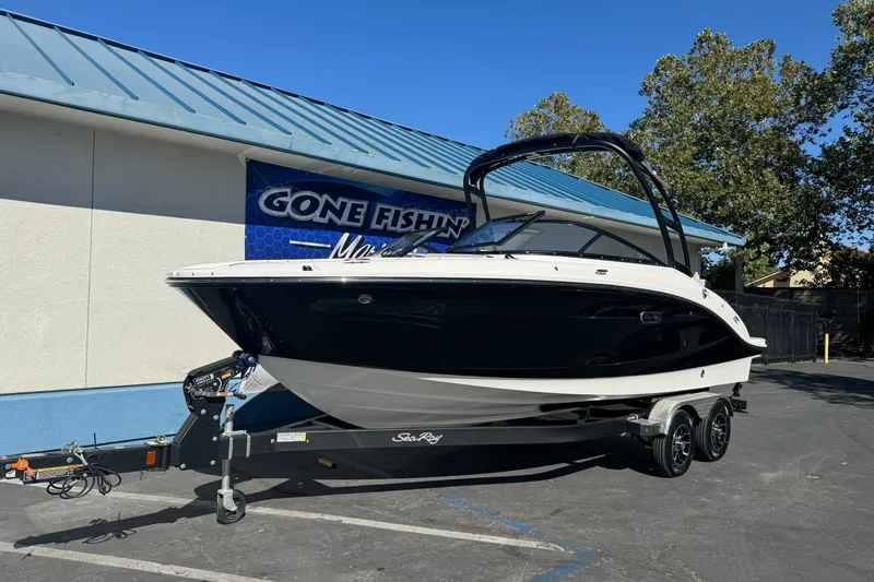 Slide: The Image of 2026 Sea Ray SPX 210 boat on trailer outside dealership, sunny day. - 1