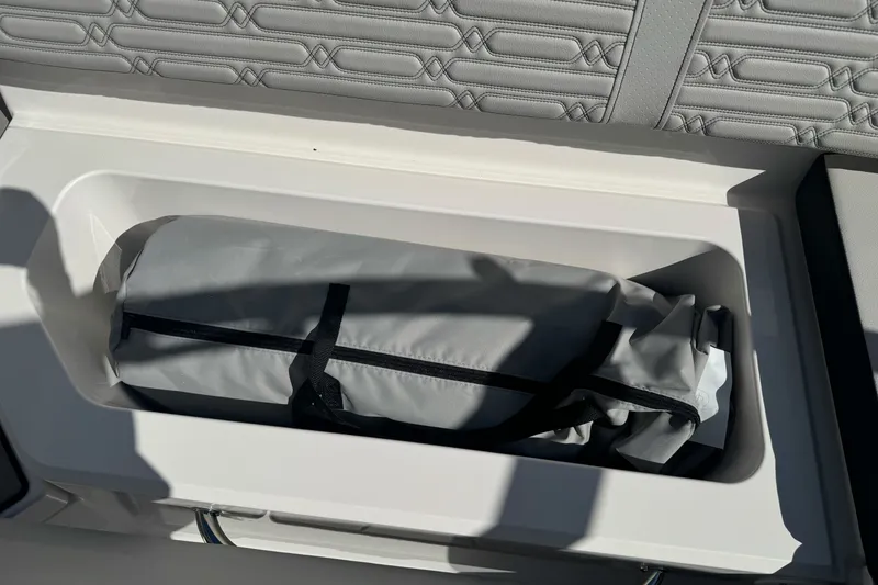 Slide: The Image of Storage compartment in 2026 Sea Ray SPX 210 boat with gray bag inside. - 25