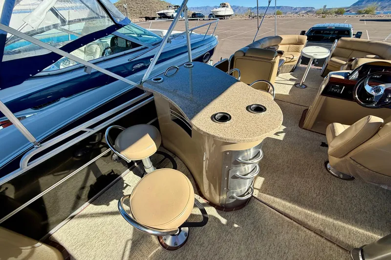 Slide: The Image of 2014 South Bay 724 E DLX TT pontoon boat interior with seating and bar area. - 11