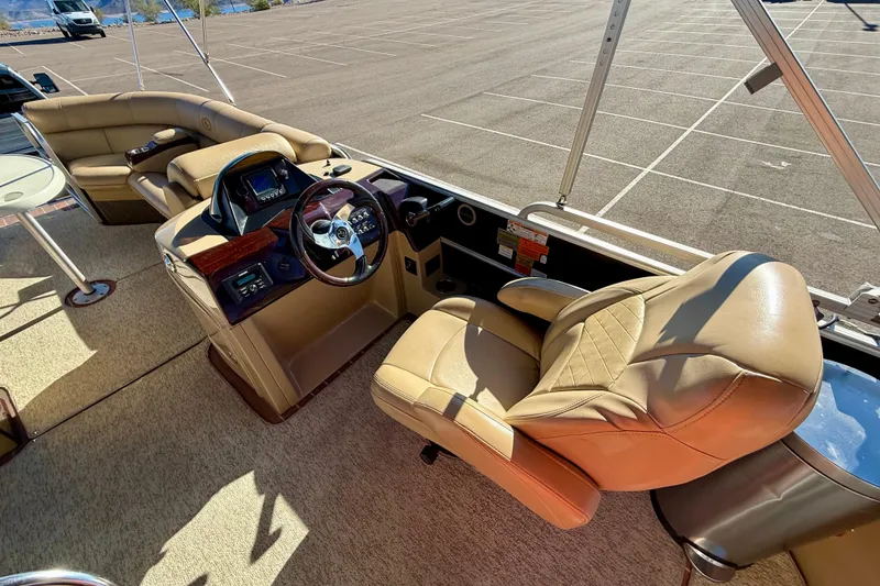 Slide: The Image of 2014 South Bay 724 E DLX TT boat interior with beige seating and steering console. - 12