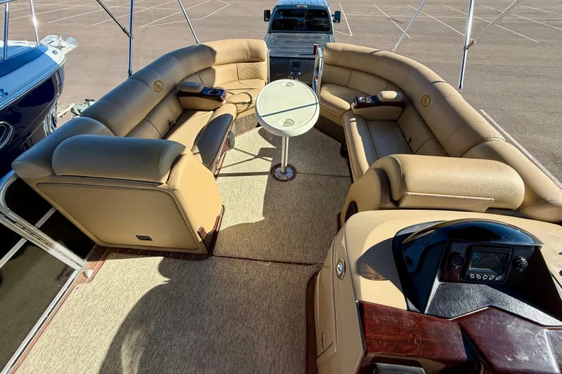 Slide: The Image of Luxurious 2014 South Bay 724 E DLX TT pontoon boat interior with plush seating and table. - 13