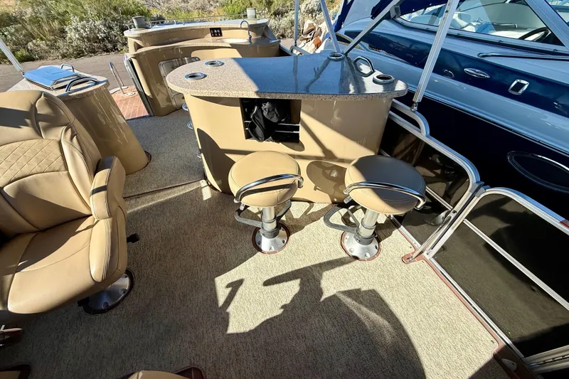 Slide: The Image of 2014 South Bay 724 E DLX TT boat interior with beige seating and bar area. - 14