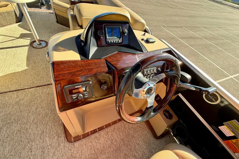 Slide: The Image of 2014 South Bay 724 E DLX TT boat helm with steering wheel and control panel. - 15