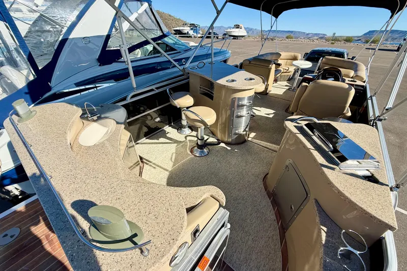 Slide: The Image of 2014 South Bay 724 E DLX TT pontoon boat interior with seating and helm station. - 8