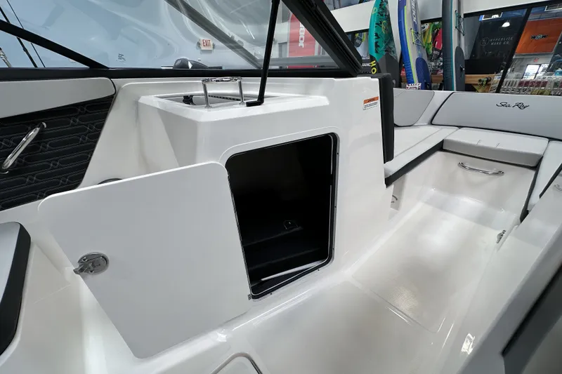 Slide: The Image of 2026 Sea Ray SPX 210 Outboard interior with open storage compartment and seating area. - 13