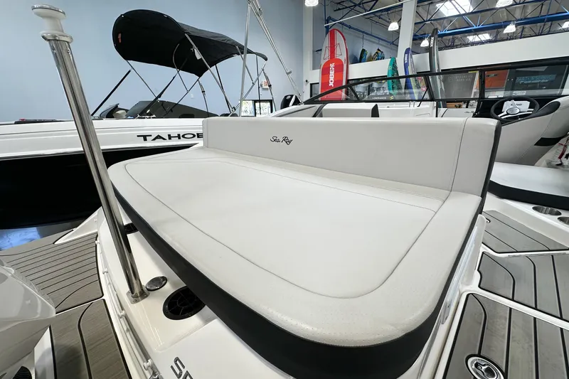 Slide: The Image of 2026 Sea Ray SPX 210 Outboard boat interior with cushioned seating in showroom. - 4