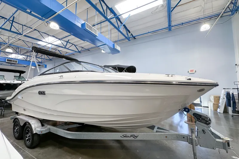 Slide: The Image of 2026 Sea Ray SPX 210 Outboard boat displayed indoors on a trailer. - 0