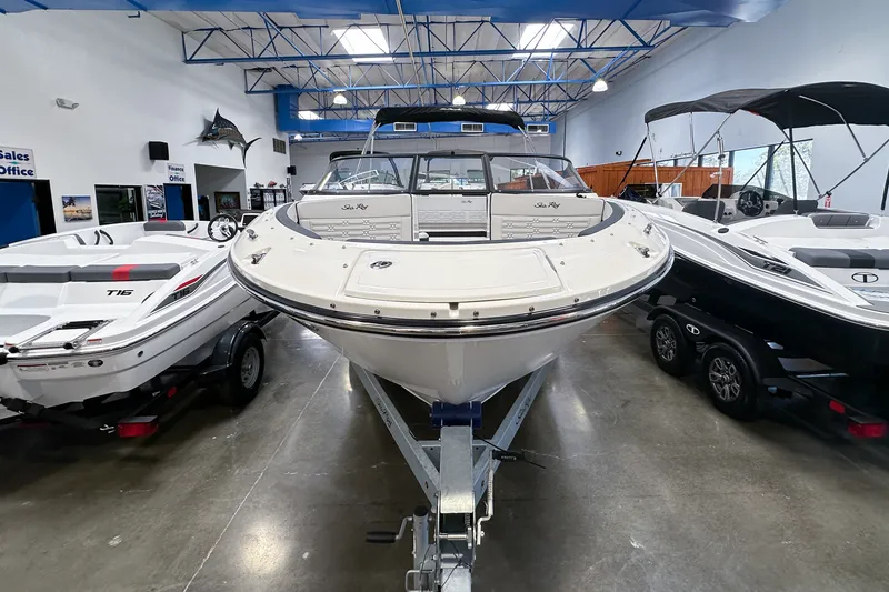 Slide: The Image of 2026 Sea Ray SPX 210 Outboard boat displayed in showroom, surrounded by other boats. - 2