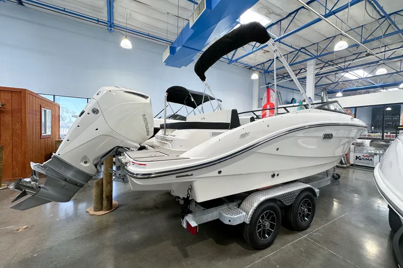 Slide: The Image of 2026 Sea Ray SPX 210 Outboard boat on trailer in showroom, featuring sleek design and powerful engine. - 1
