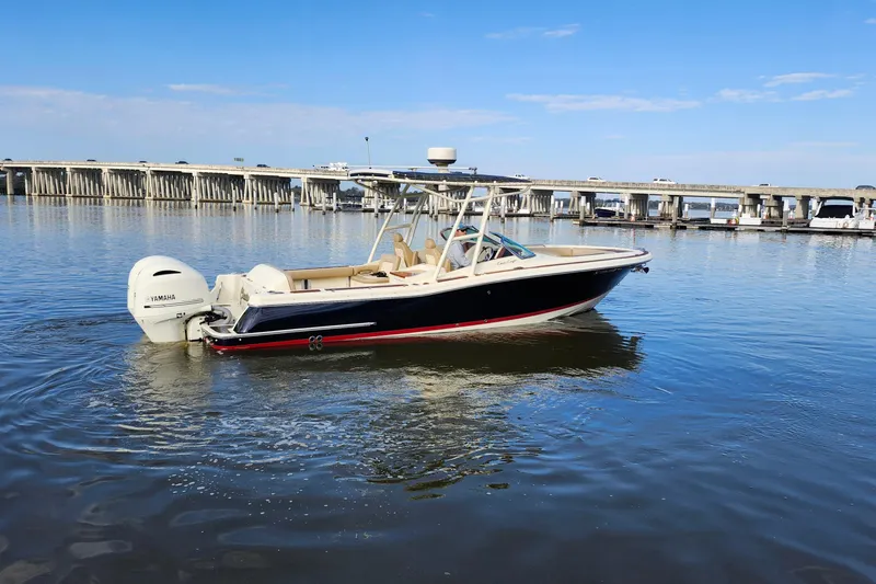 Slide: The Image of 2016 Chris-Craft Calypso 26 boat on calm water near a bridge. - 13