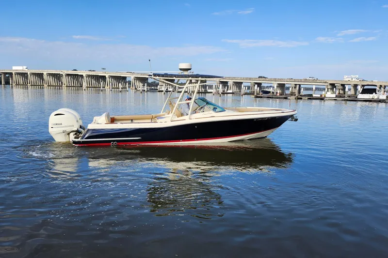 Slide: The Image of 2016 Chris-Craft Calypso 26 boat on calm water near a bridge. - 14