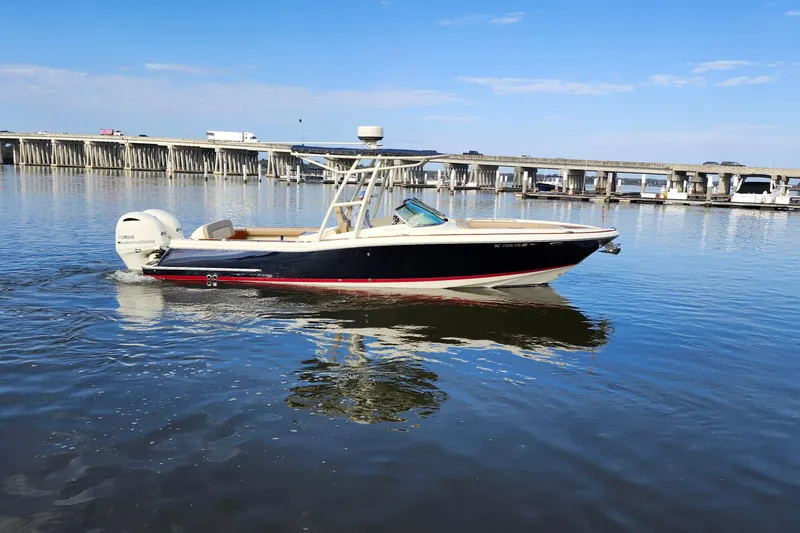 Slide: The Image of 2016 Chris-Craft Calypso 26 boat on calm water near a bridge. - 15