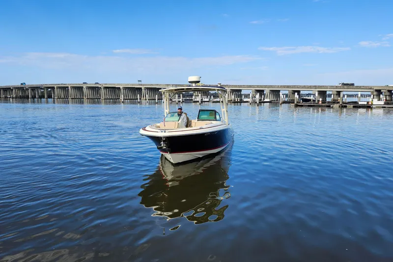 Slide: The Image of 2016 Chris-Craft Calypso 26 boat on calm water near a bridge. - 17