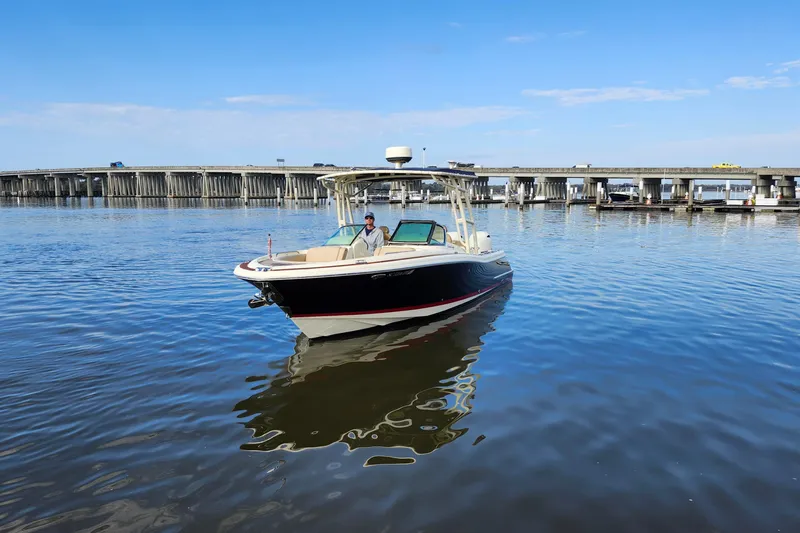 Slide: The Image of 2016 Chris-Craft Calypso 26 boat on calm water near a bridge. - 18