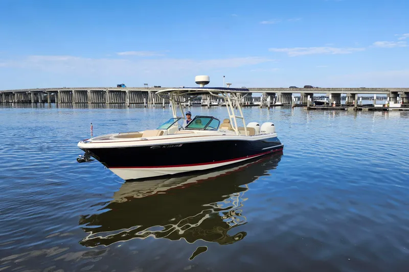 Slide: The Image of 2016 Chris-Craft Calypso 26 boat on calm water near a bridge. - 19