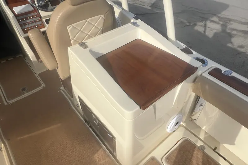 Slide: The Image of 2016 Chris-Craft Calypso 26 boat interior with beige seating and wooden accents. - 20