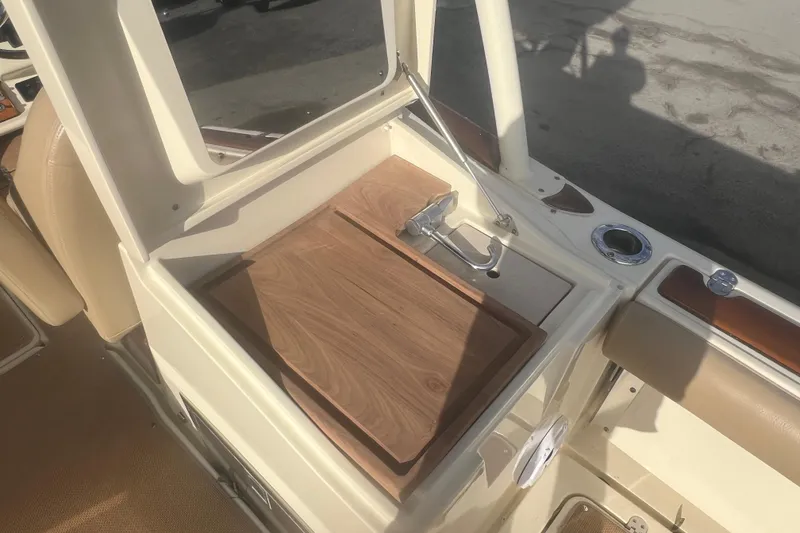 Slide: The Image of 2016 Chris-Craft Calypso 26 boat interior with wooden panel and faucet. - 21
