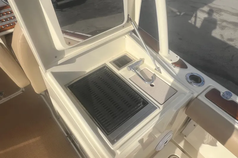 Slide: The Image of 2016 Chris-Craft Calypso 26 boat interior with grill and sink setup. - 22