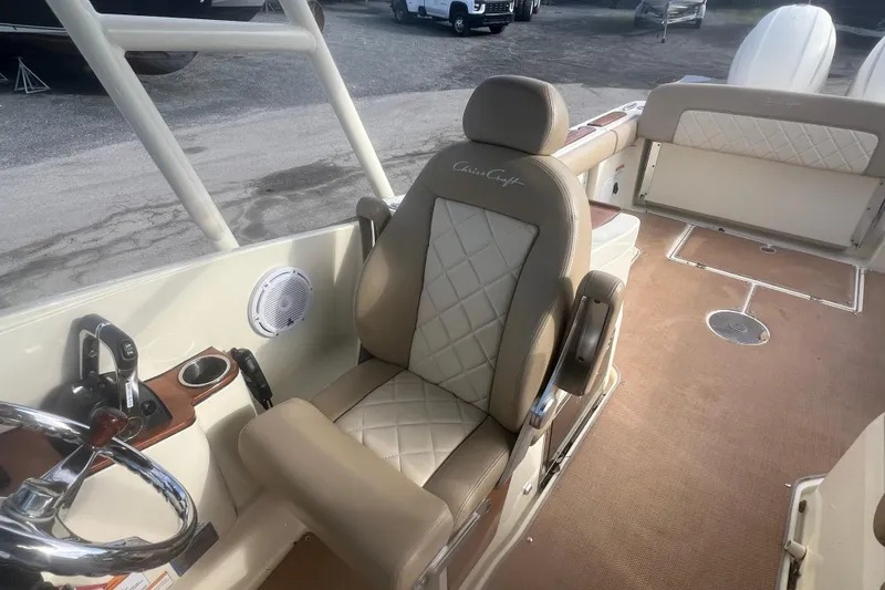 Slide: The Image of 2016 Chris-Craft Calypso 26 boat interior with luxurious seating and steering wheel. - 27