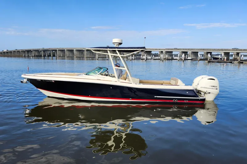 Slide: The Image of 2016 Chris-Craft Calypso 26 boat on calm water with bridge in background. - 3