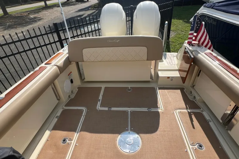 Slide: The Image of 2016 Chris-Craft Calypso 26 boat interior with dual engines and American flag. - 30