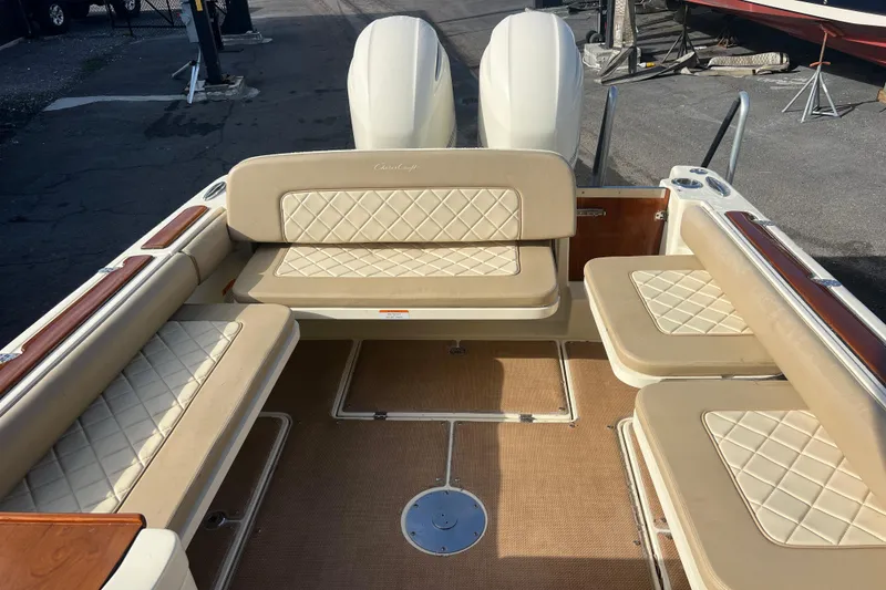 Slide: The Image of 2016 Chris-Craft Calypso 26 boat interior with beige cushioned seating and wood accents. - 31