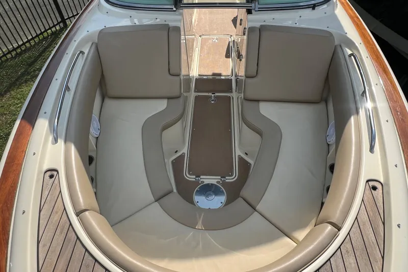 Slide: The Image of 2016 Chris-Craft Calypso 26 boat interior with beige seating and wooden accents. - 35