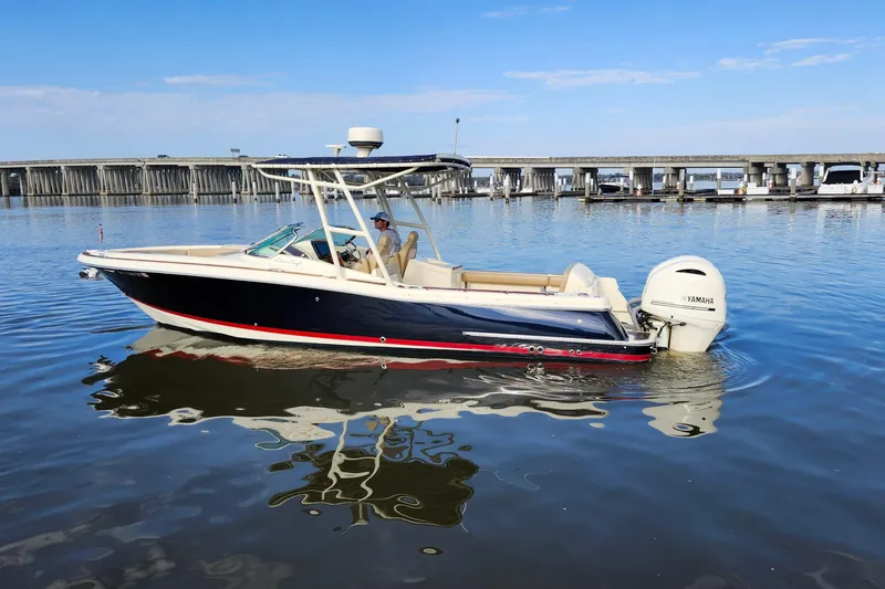 Slide: The Image of 2016 Chris-Craft Calypso 26 boat on calm water near a bridge. - 4