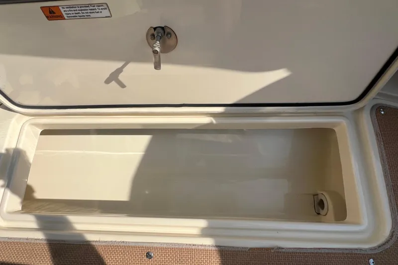 Slide: The Image of Open storage compartment on a 2016 Chris-Craft Calypso 26 boat. - 42