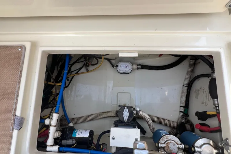 Slide: The Image of Engine compartment of a 2016 Chris-Craft Calypso 26 boat, showing various mechanical components. - 44