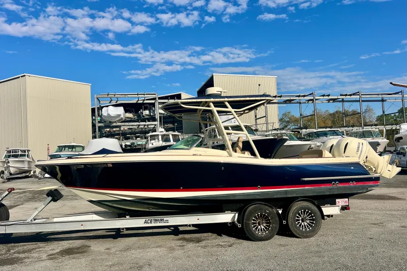 Slide: The Image of 2016 Chris-Craft Calypso 26 boat on trailer, marina background, clear sky. - 45