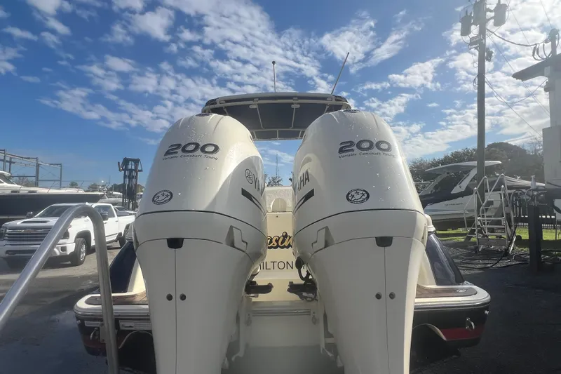 Slide: The Image of 2016 Chris-Craft Calypso 26 with twin Yamaha 200 engines, parked under a clear blue sky. - 46