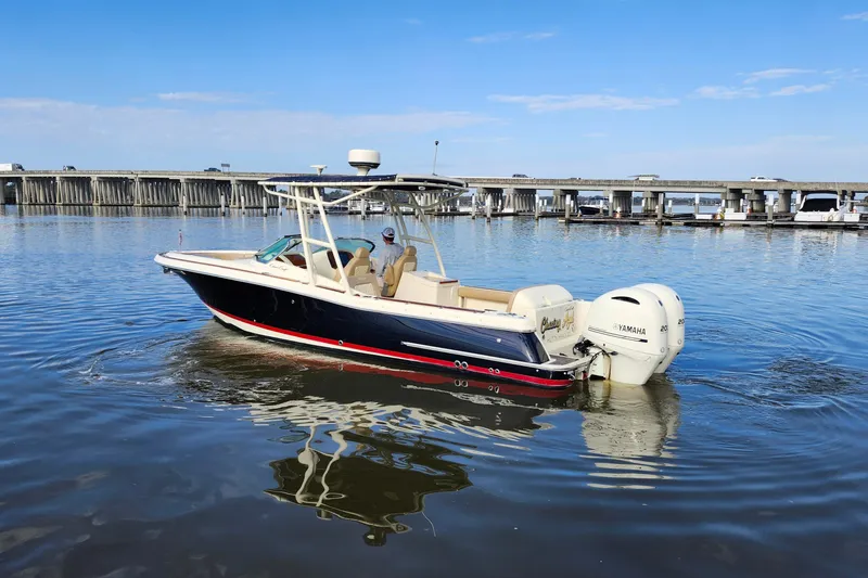 Slide: The Image of 2016 Chris-Craft Calypso 26 boat on calm water near a bridge. - 6